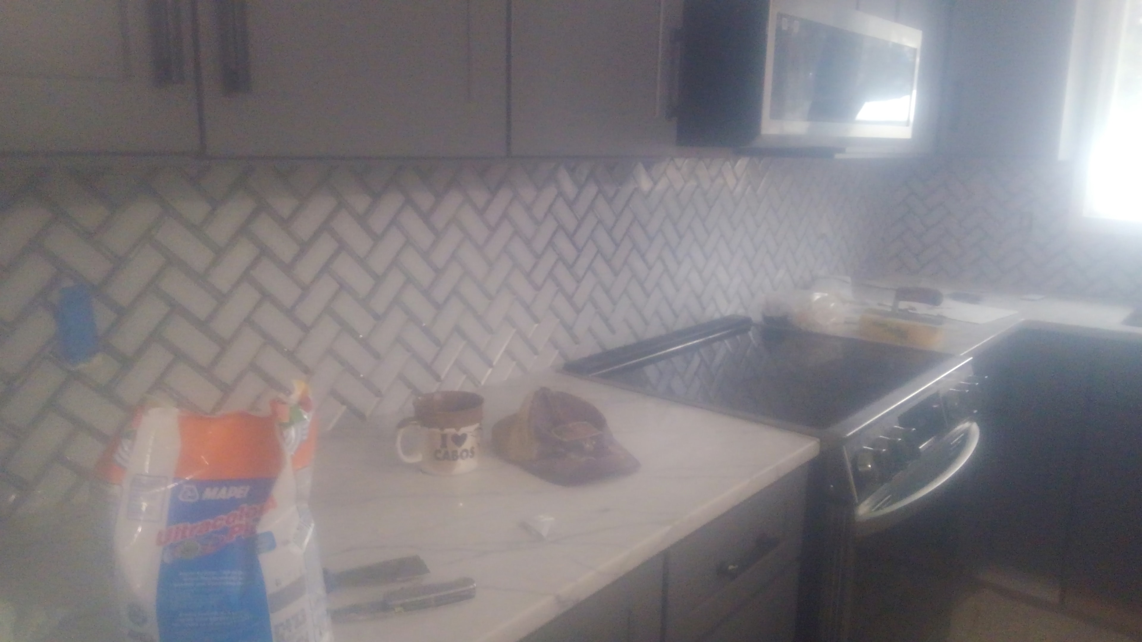 Freestanding soaking tub with subway tile and dark tile floor