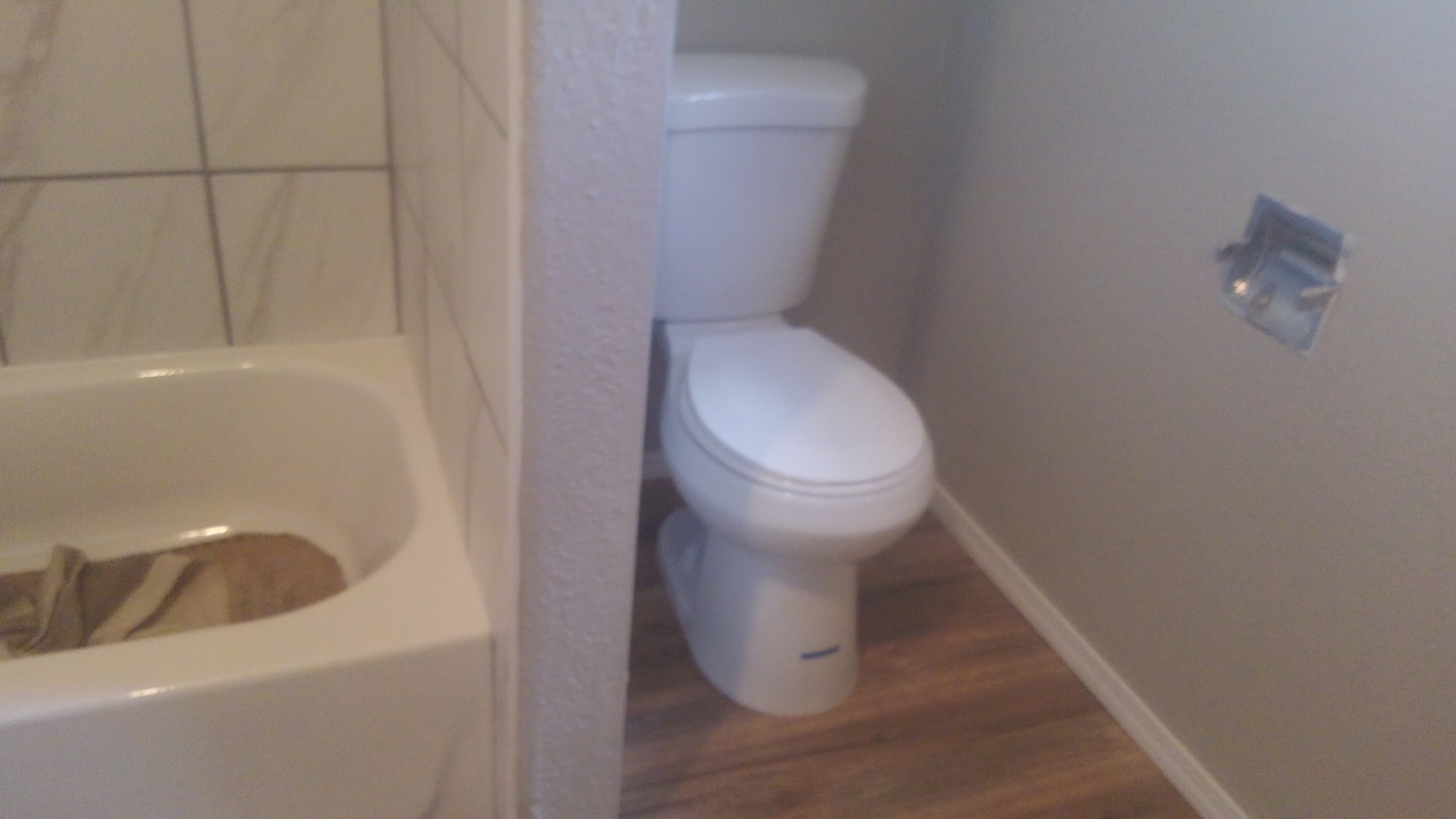 Completed bathroom with marble-look tile and LVP flooring