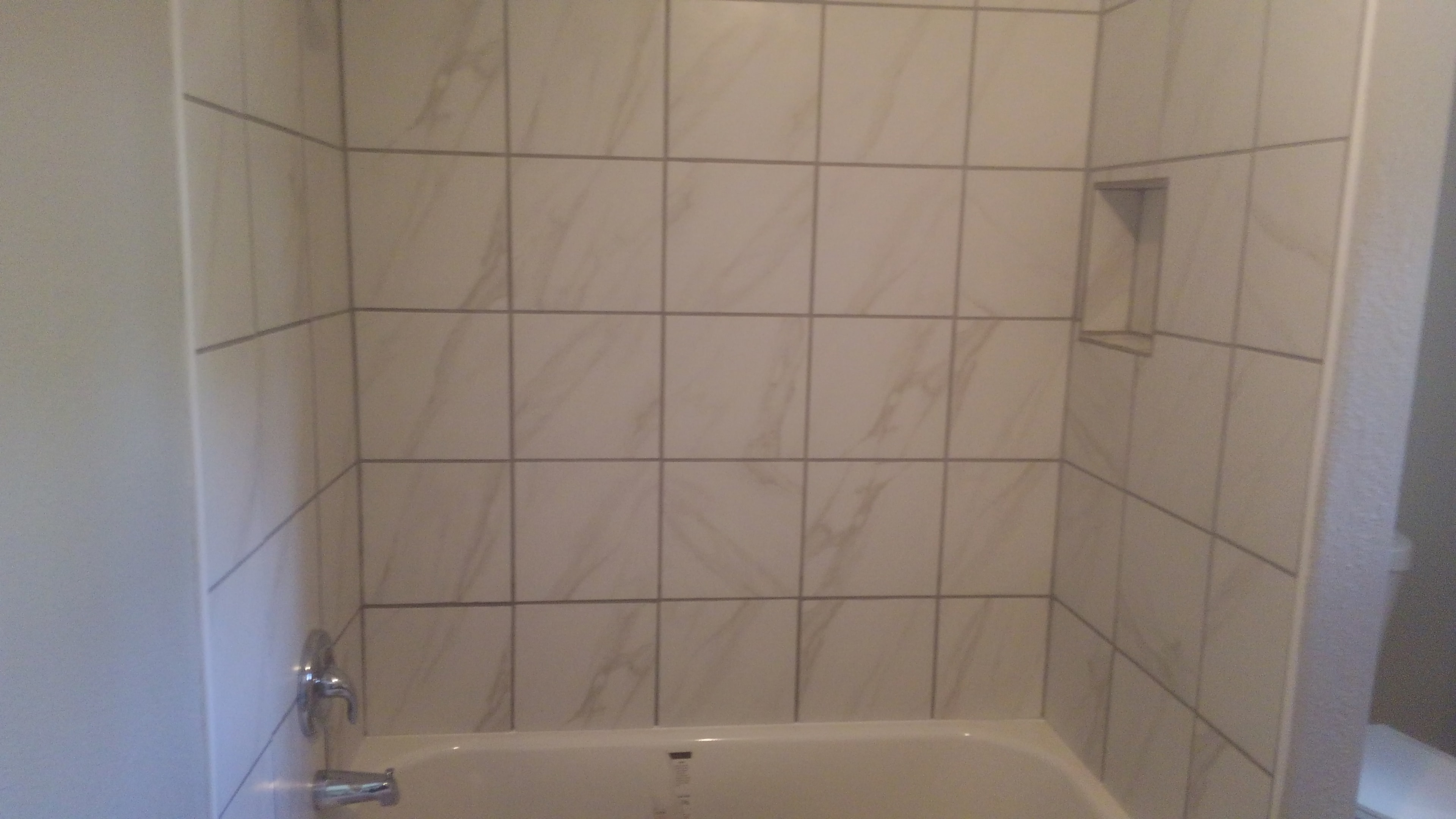Marble-look tile tub surround with built-in niche