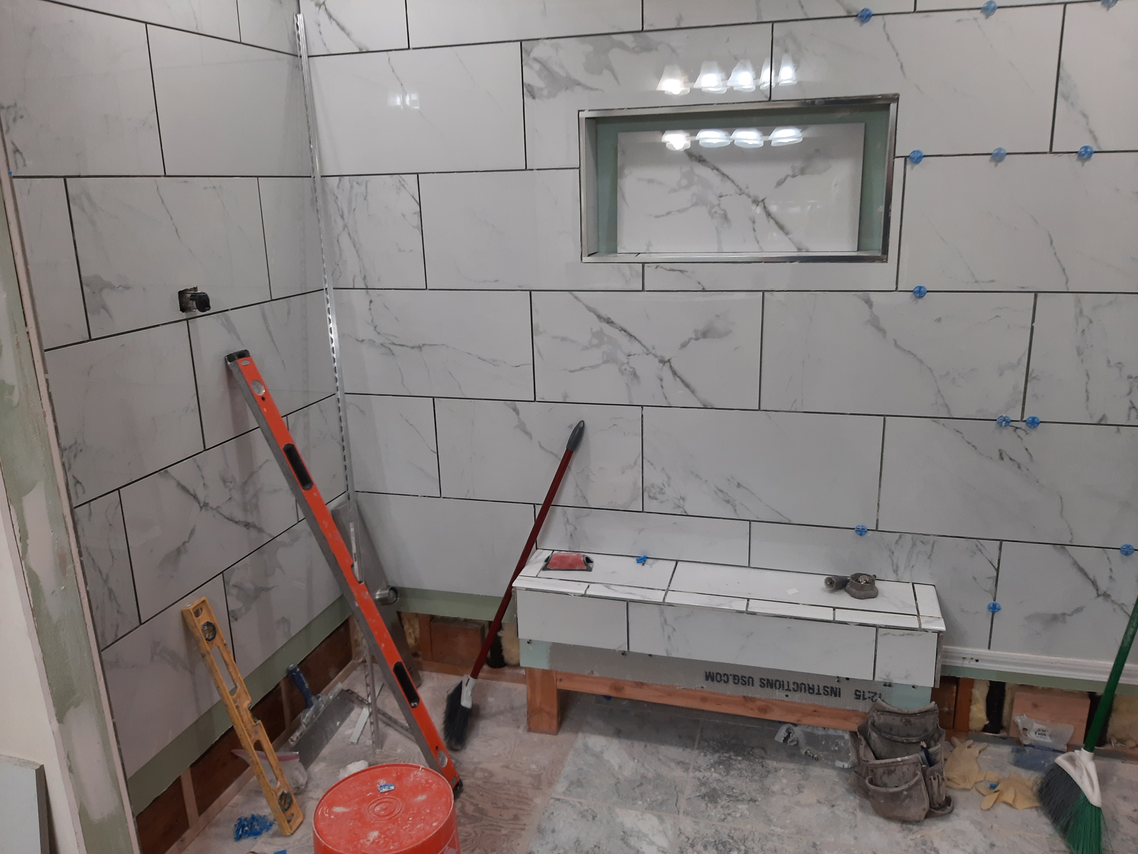 Marble tile shower with niche and bench seat