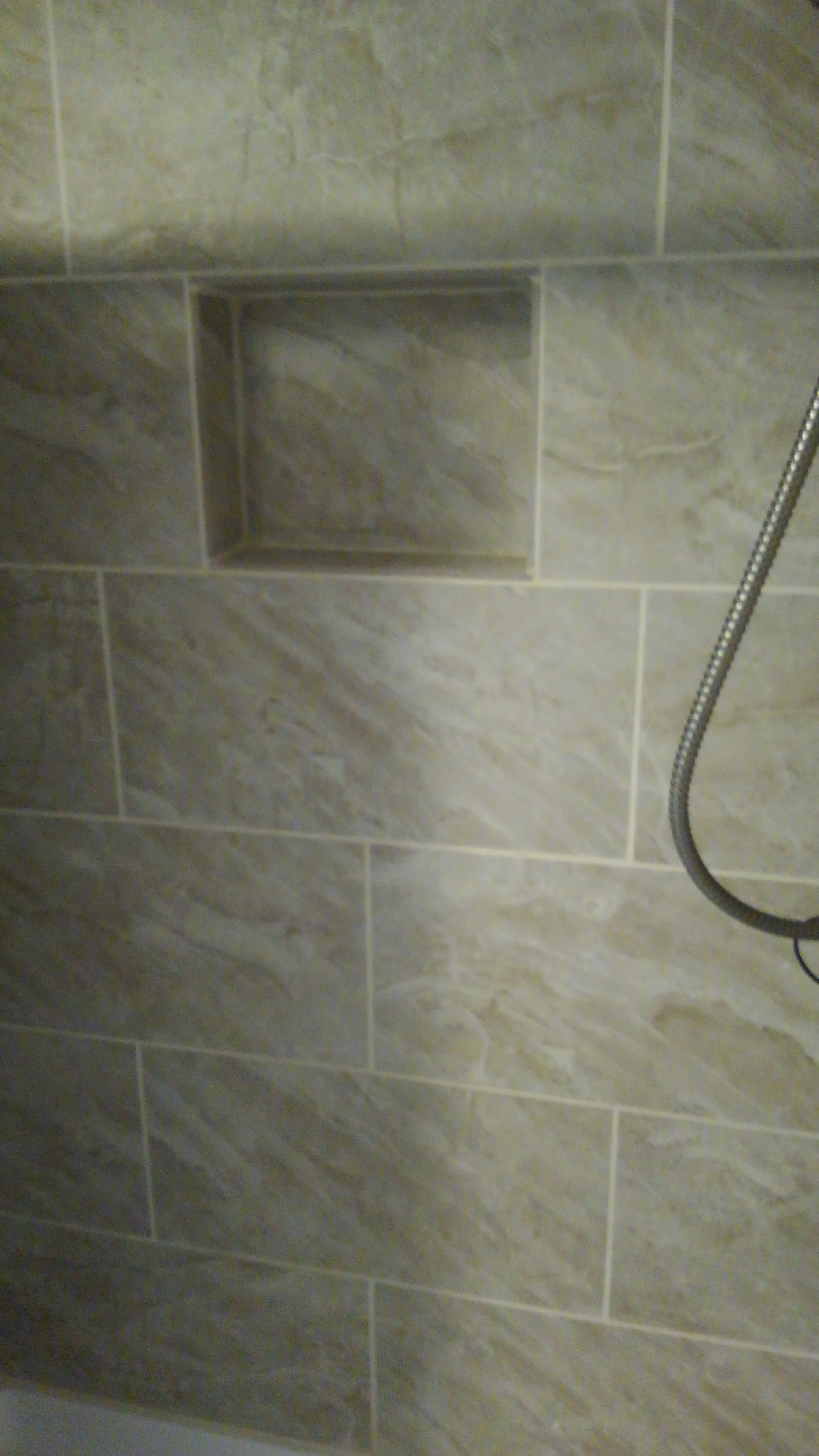 Travertine shower wall with built-in niche