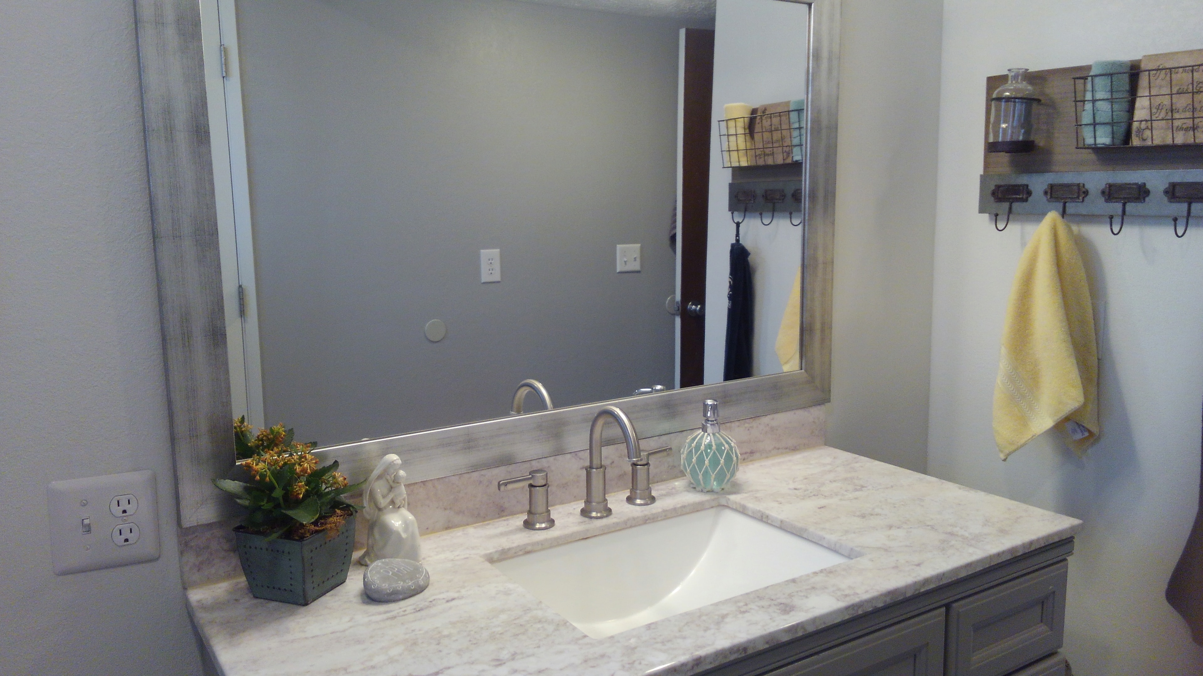Bathroom vanity with marble soffit and large mirror