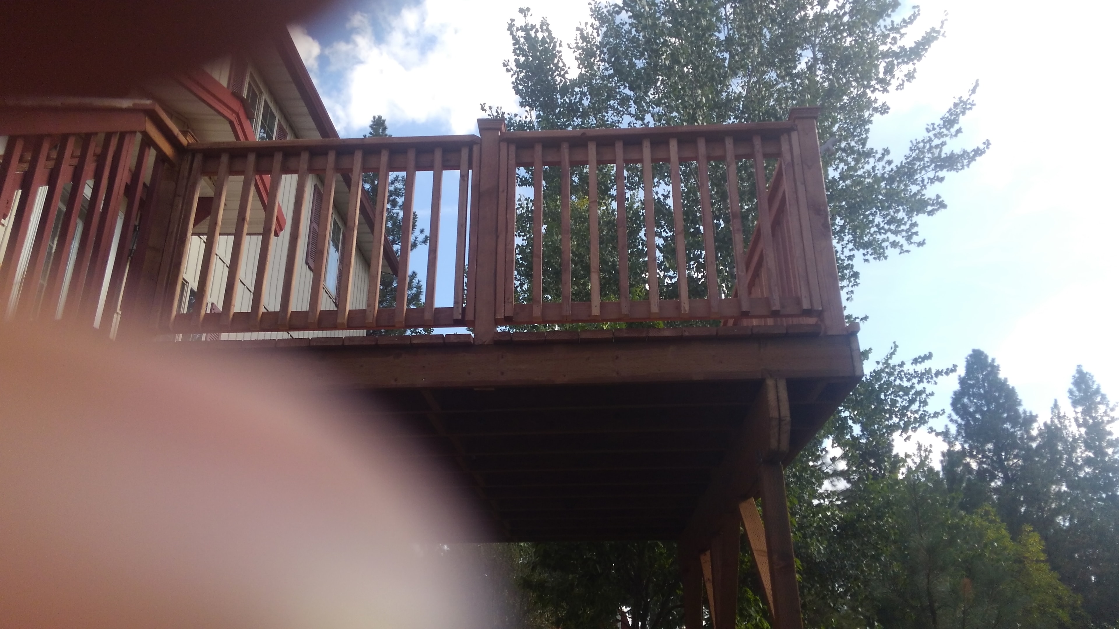 Second-story deck with tree canopy backdrop