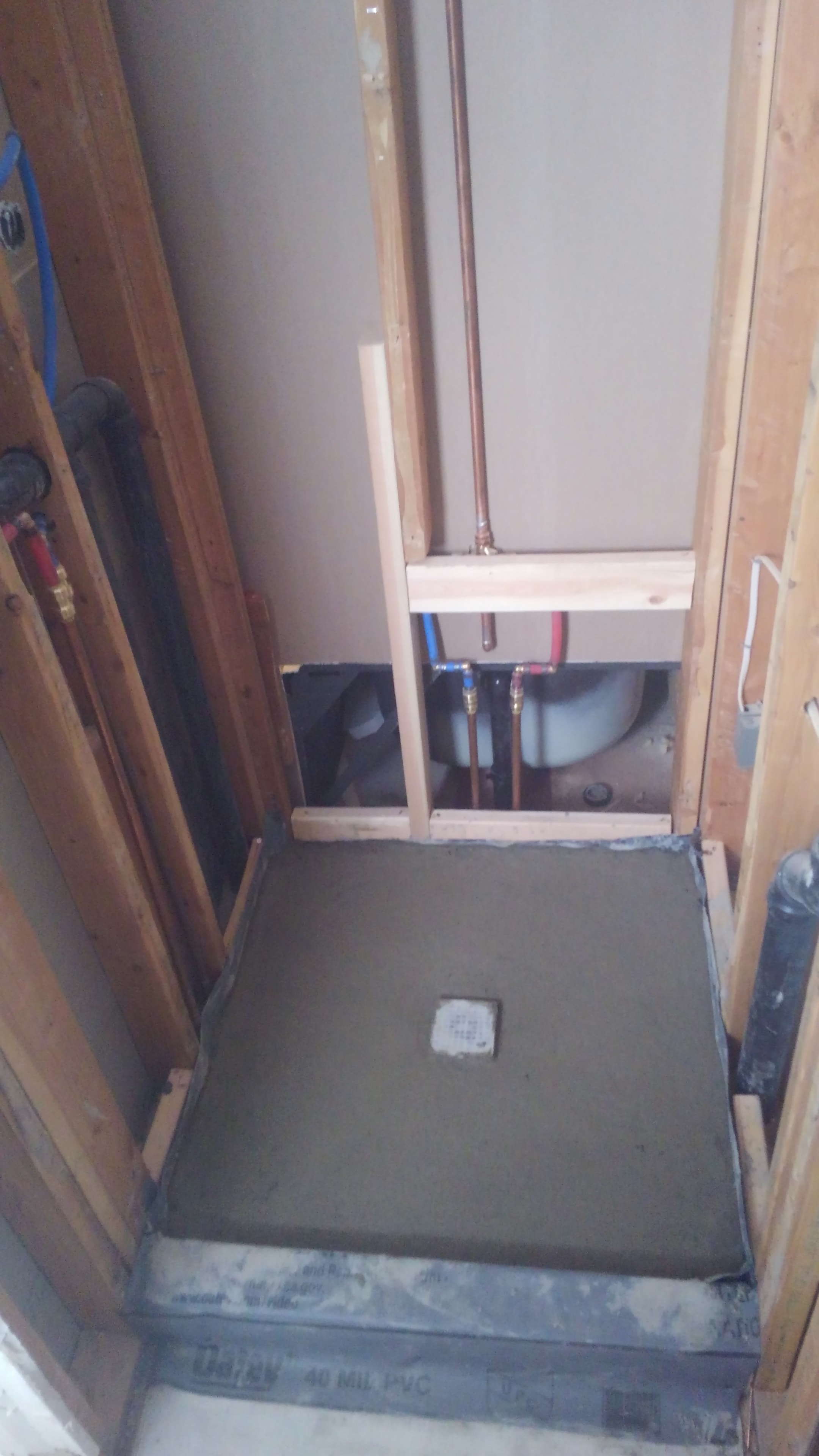 Shower rough-in with exposed framing and plumbing