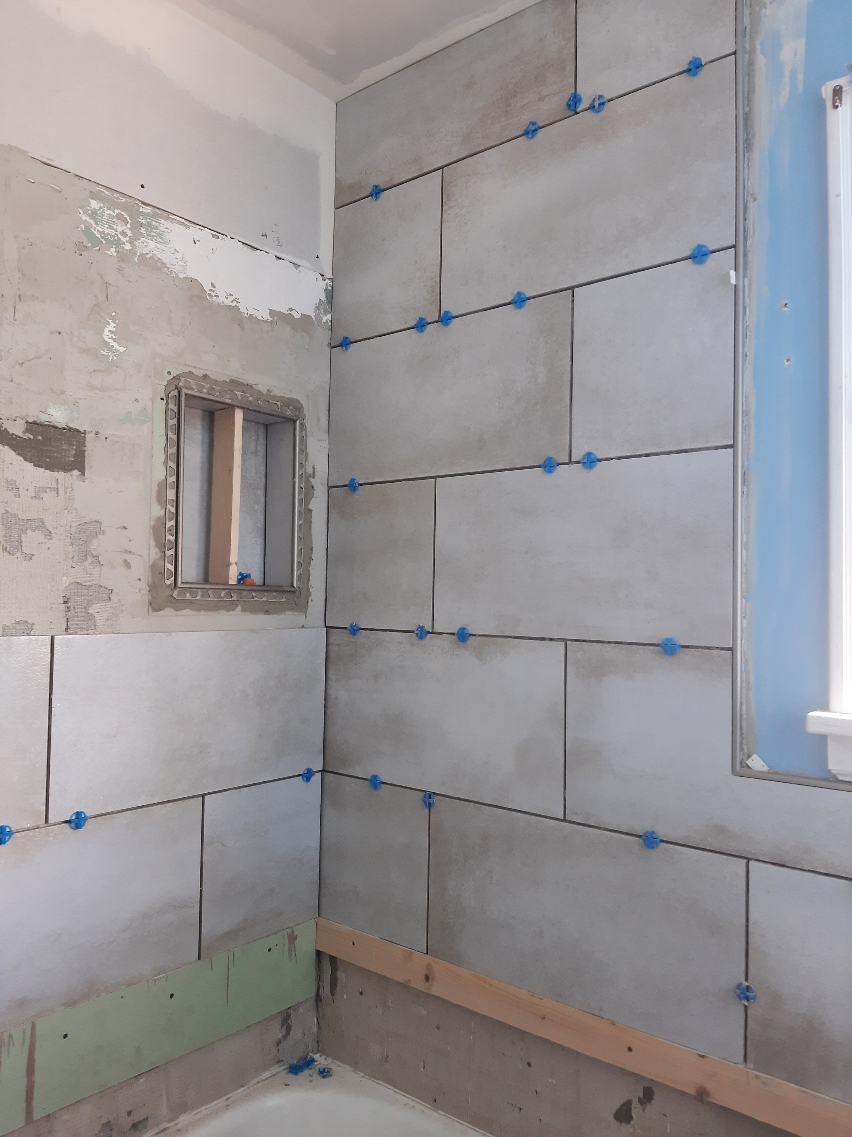 Large-format shower floor tile with linear drain